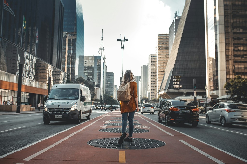Женщина идёт по красной велодорожке на Avenida Paulista, Сан-Паулу
